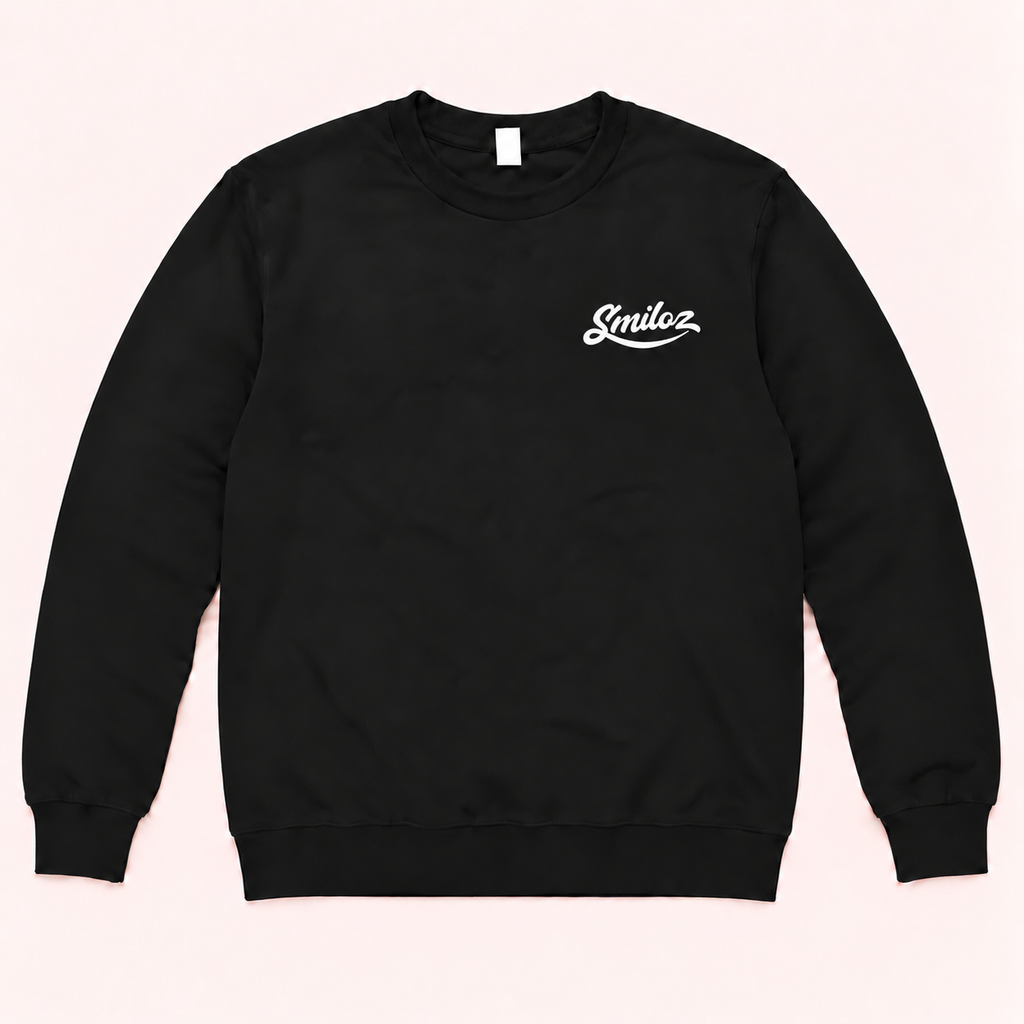 Front of black Smiloz crewneck jumper with original-style white script chest logo on a blush background